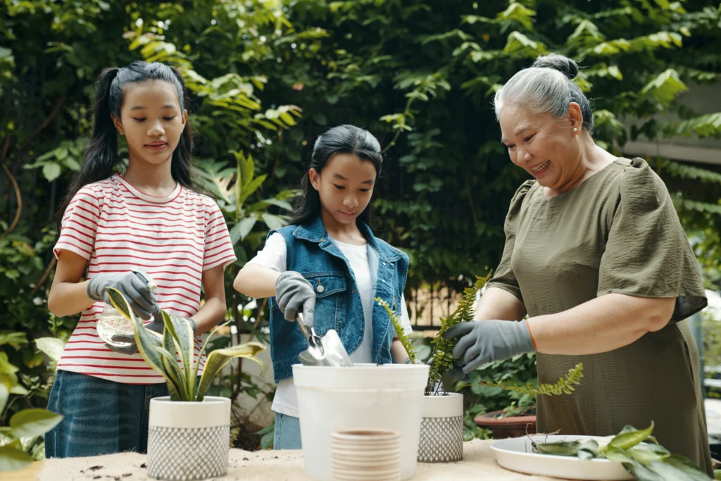 Grandmother teaching her granddaughters to work with plants